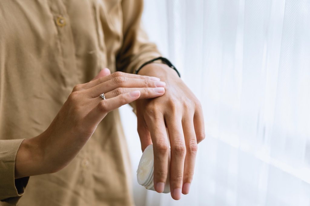 Close-up of a woman's hands applying cream.